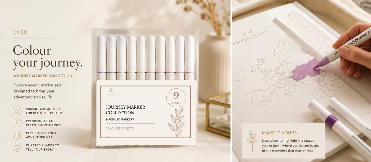 A set of 9 JOURNEY Marker Collection acrylic markers in a cream-colored box, shown alongside a hand coloring in a notebook with a purple marker. The left side features warm beige background graphics with product details, and the right side shows the markers in use.