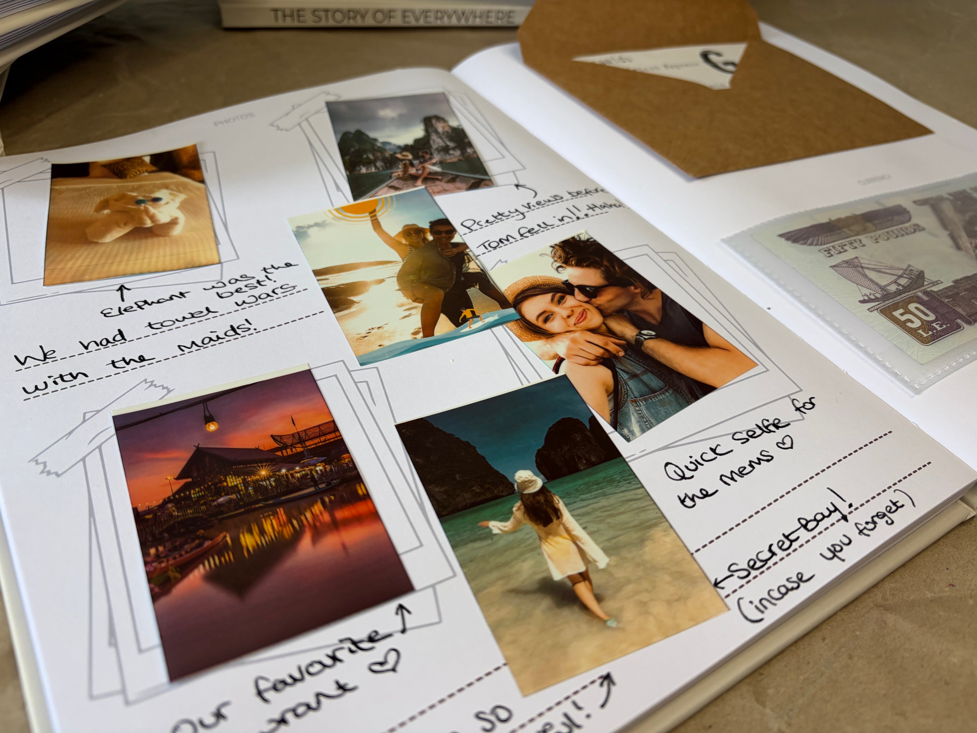 An open handmade photo album or scrapbook page laid on a beige surface, showing several printed photos, handwritten notes, and decorative dashed lines. A brown envelope is partially visible at the top right.